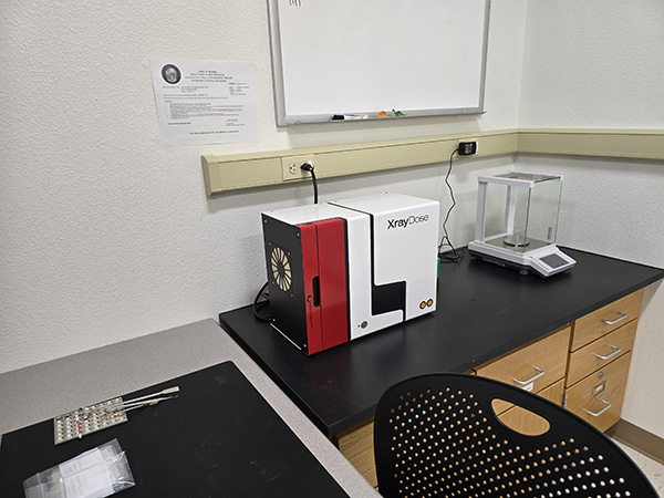 A piece of equipment is sitting on a counter in the corner of a lab. 