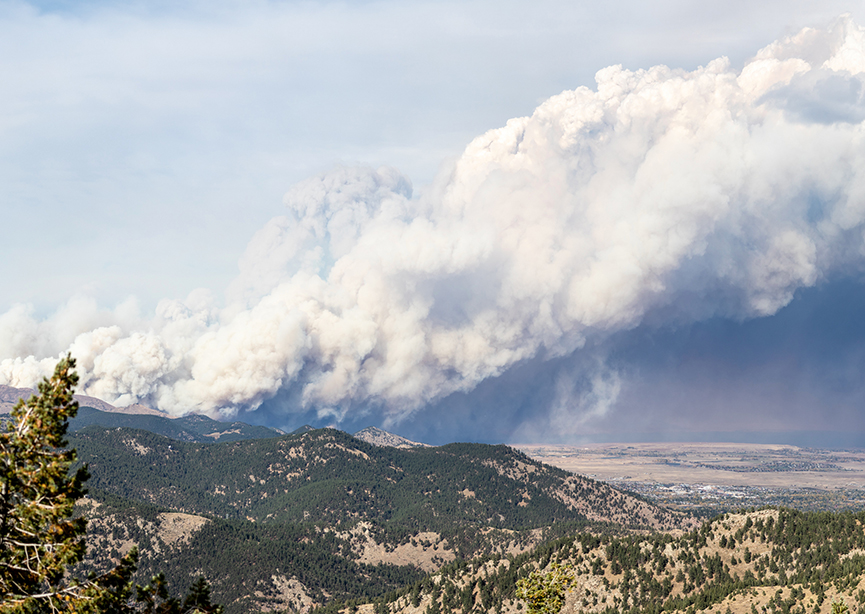 Wildfire with ash cloud seen from afar.