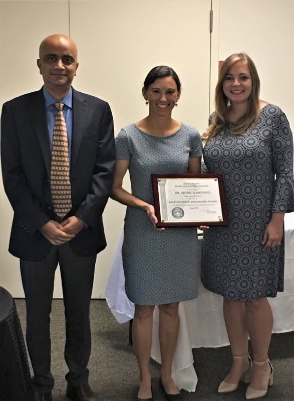 Dr. Kumud Acharya and Regent Amy Carvalho present the Regents Rising Researcher Award to Dr. Monica Arienzo (center).