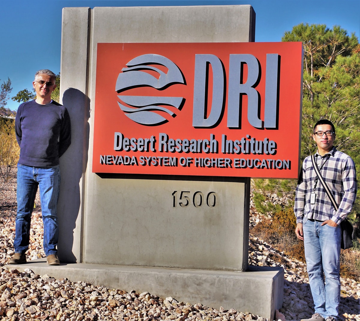 Researchers Markus Berli and Yuan Luo near a sign for the Desert Research Institute