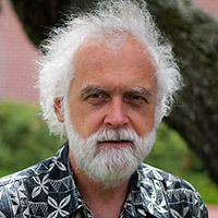 Headshot of Bill outside with a white beard and wearing a printed shirt.