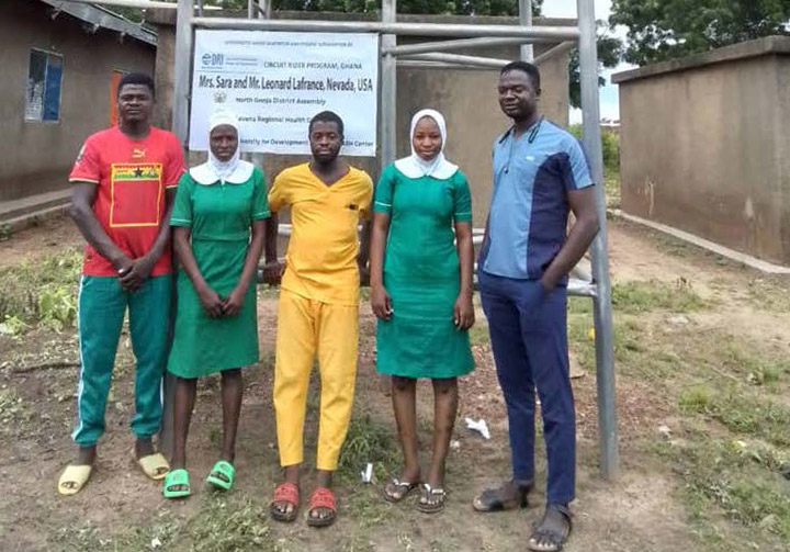 People standing in front of a water tower.