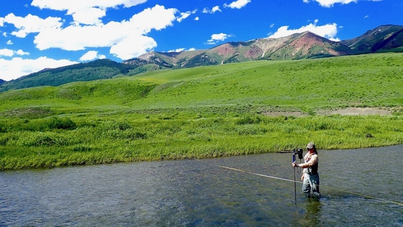 female scientist in water measure stream discharge