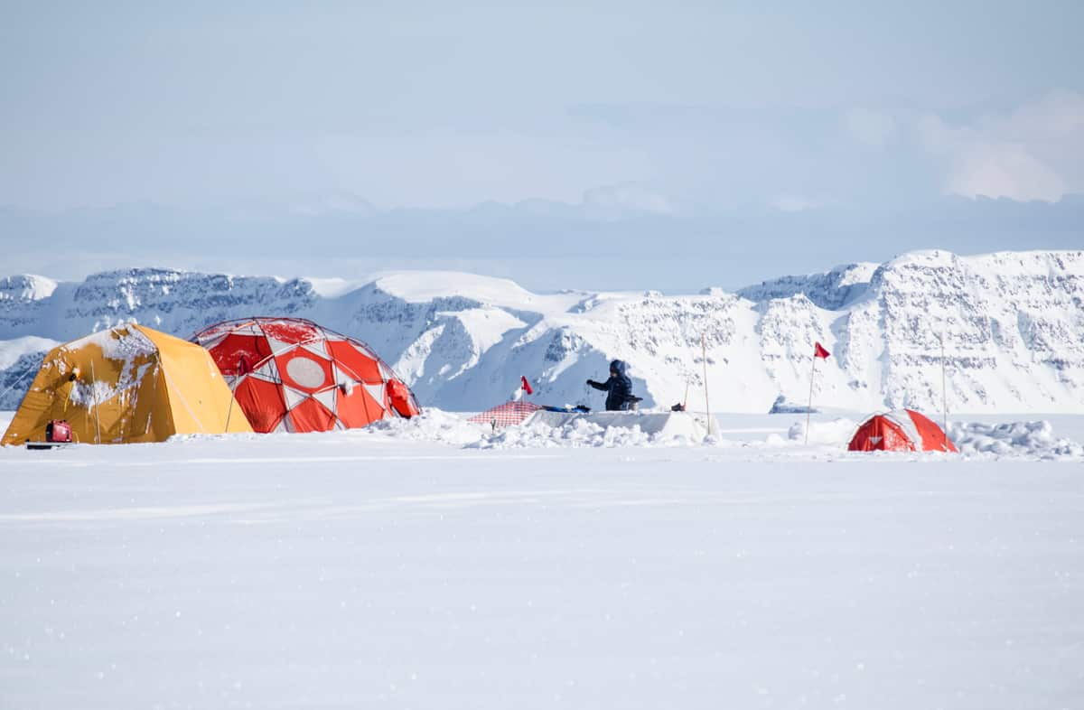 The research team on the ground of a coastal West Greenland ice cap, preparing to extract and examine ice cores. 