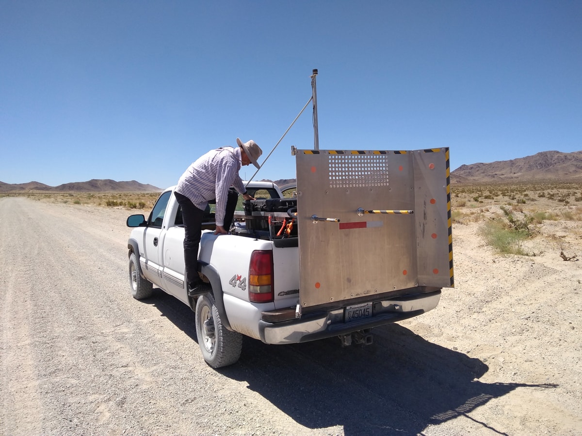 Researcher preparing the TRAKER instrument for measuring and collecting dust from unpaved roads