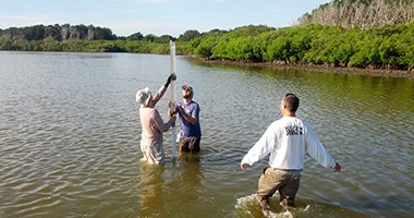 researchers setting up measurement instrument in lake