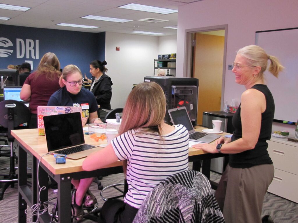 Women working on computers at a table.