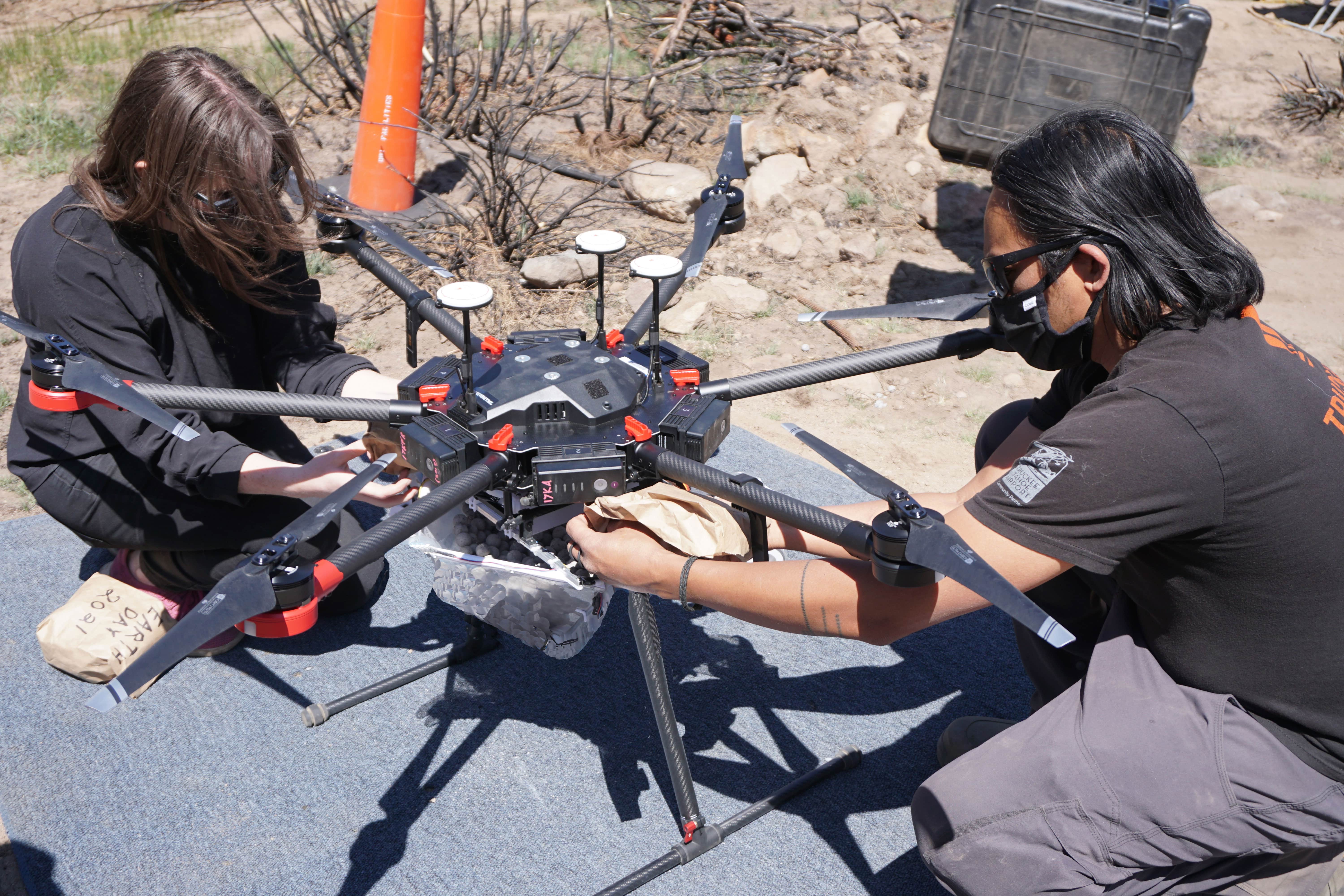 two people perform maintenance and analysis on drone after flight