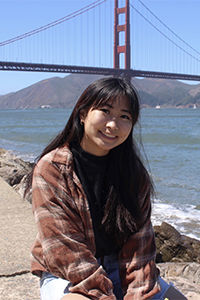 Helen sitting in front of the golden gate bridge smiling.