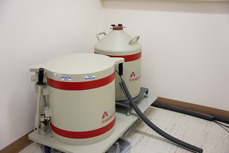 Two white and red tanks in the corner of a lab. 