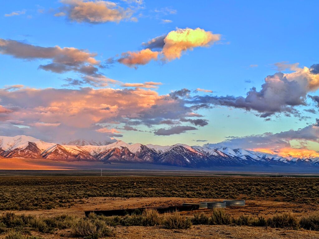 Landscape of mountains in Nevada topped with snow at sunset.