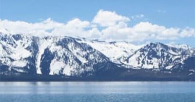 Mountain Rain or Snow Blurb Landscape view of mountains covered in snow next to a lake.