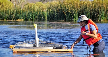 woman standing in water with floating measurement instrument