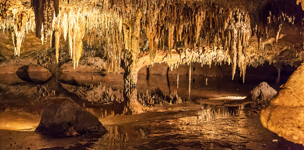 View of the inside of a cave with large stalactites and stalagmites