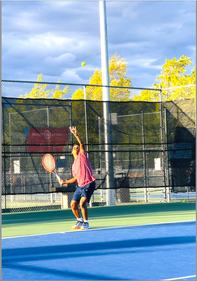 Photo of Gautam playing tennis.