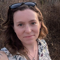 Headshot of Stacey taken outside at sunset. 