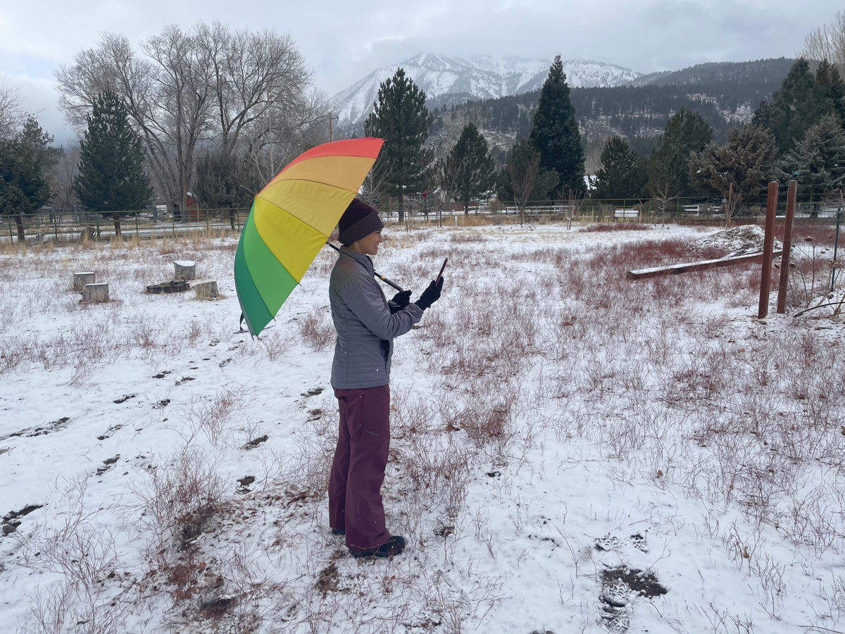 DRI scientist Monica Arienzo collects data for the Tahoe Rain or Snow project with a rainbow-colored umbrella