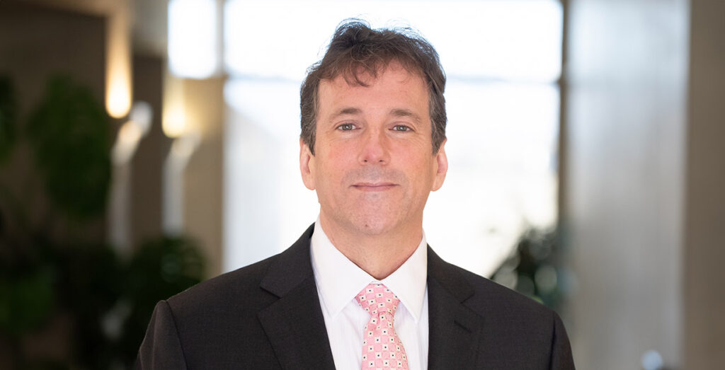 Headshot of Trey wearing a suit and tie.