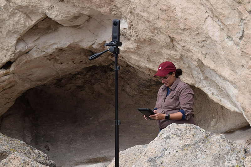DRI Archaeologist documents the rocky landscape with a 360 degree camera and tablet. 