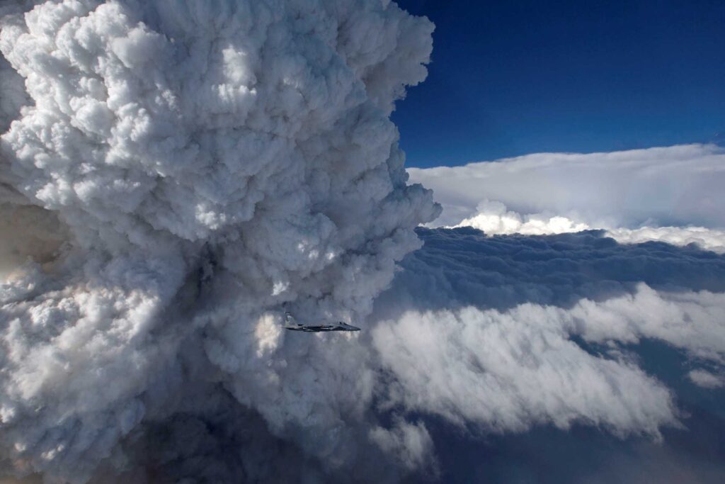 Plane in front of very large clouds.