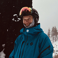 Ben outside on a snowy day with a blue coat, hat, and sun visor.