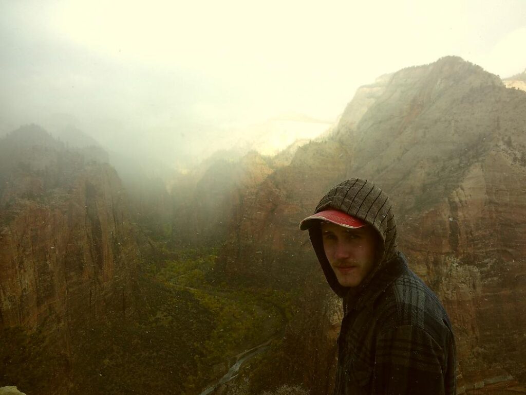 Photo of Erik overlooking the canyon at Zion National Park on a snowy day.