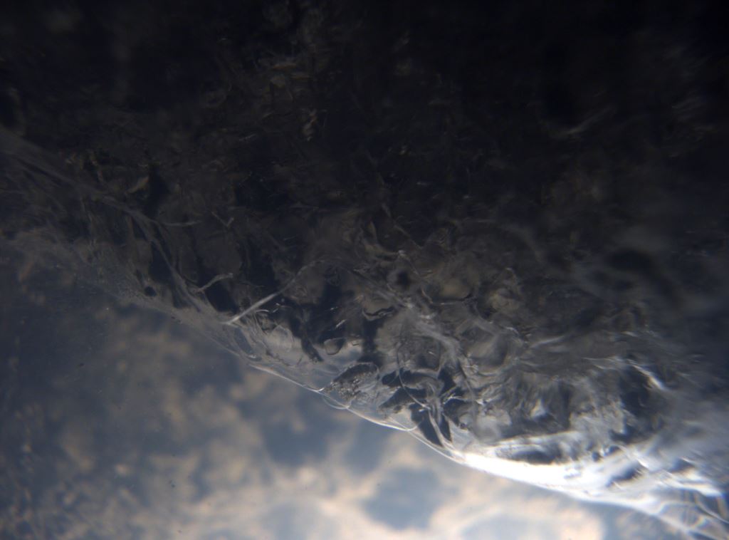 Close up image of an ice sheet meeting lake water. 