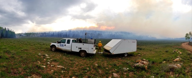 DRI truck and trailer near a prescribed fire.