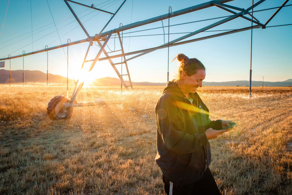 Denise on her Nevada farm looking at cell phone