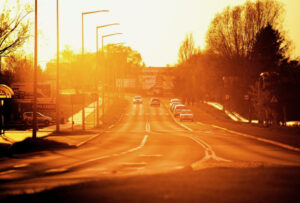Cars driving down a road on a hot day